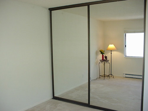 Sliding closet doors with large vanity mirrors - Remove the frame and you have one giant mirror for your garage gym
