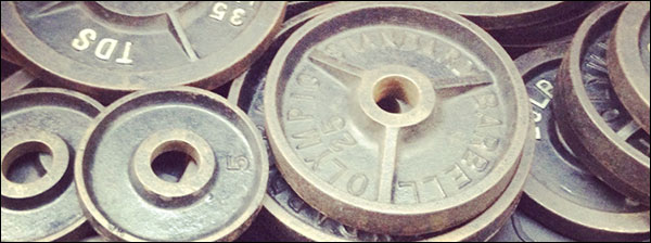 https://www.garage-gyms.com/wp-content/uploads/2017/11/mess-of-olympic-cast-iron-weights.jpg